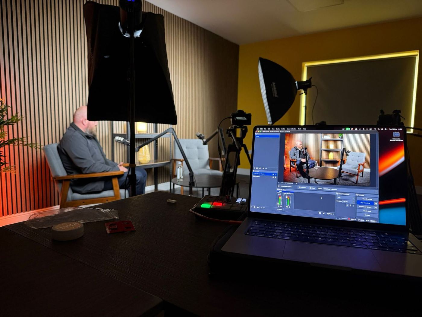 The Dragon Forge studio set with lighting, cameras and a live recording on screen